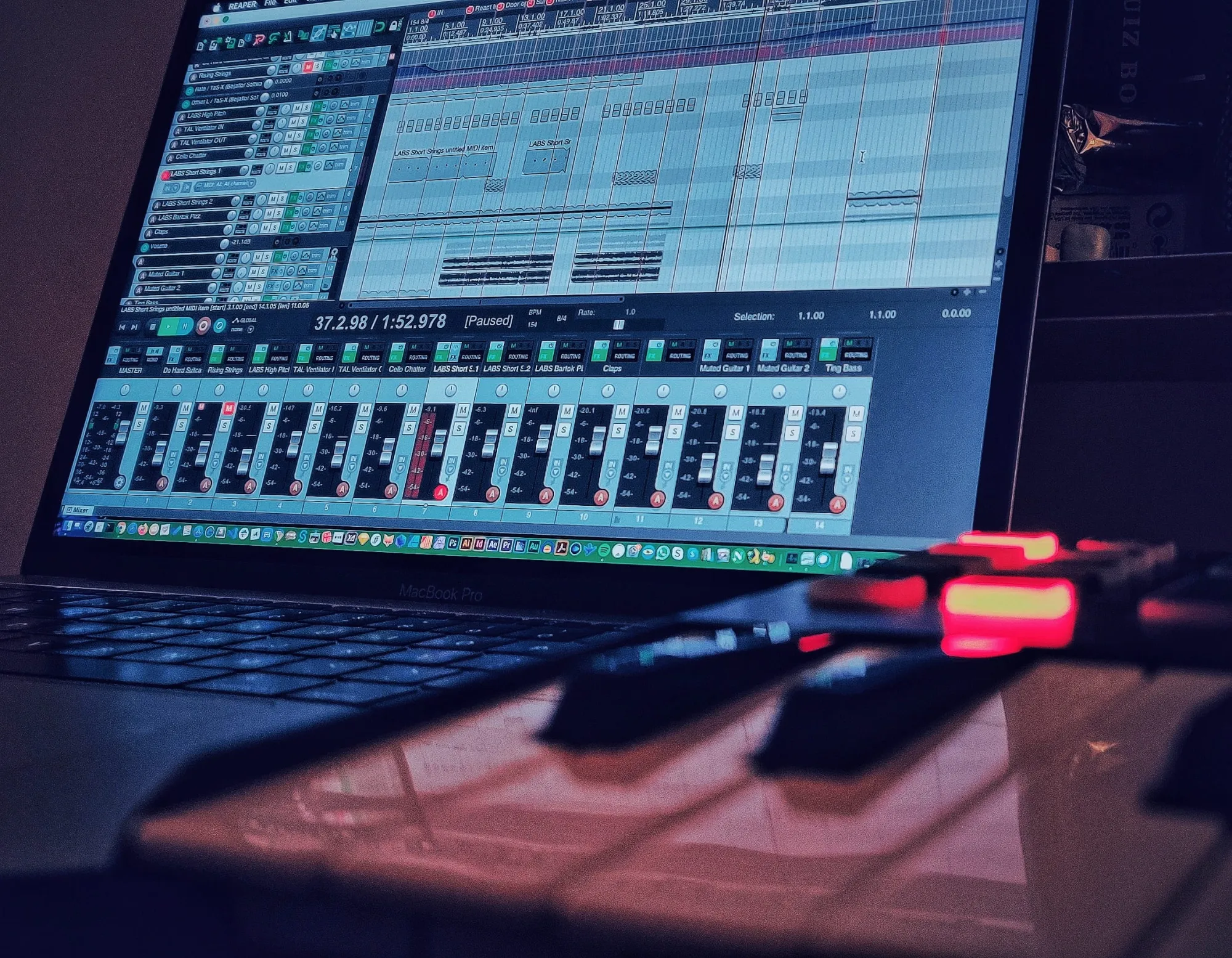 Reaper DAW session for the No Hard Shells Crack score, showing string, guitar and percussion tracks, with a MIDI keyboard in the foreground